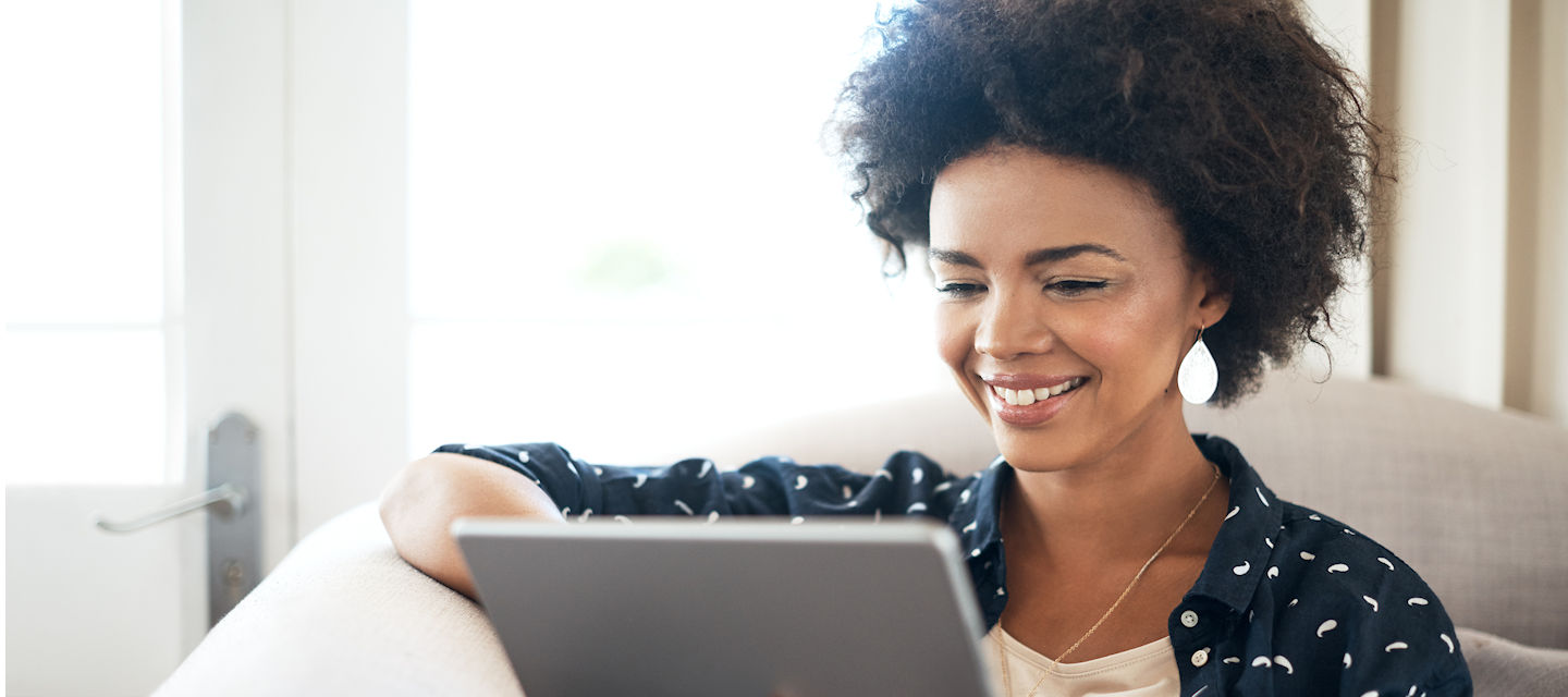 Shot of a young woman relaxing at home with her digital tablet