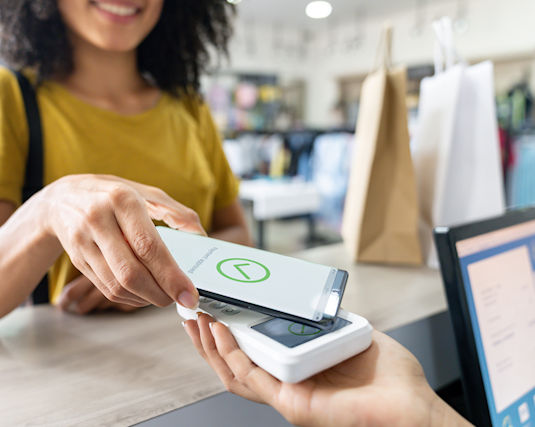 woman paying for a purchase using her smart phone and digital wallet.