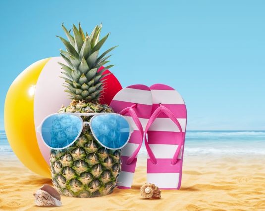 summer background with beach ball, pineapple and flip flops