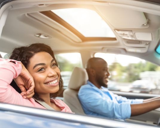 African American Couple very happy in a car taking a trip.